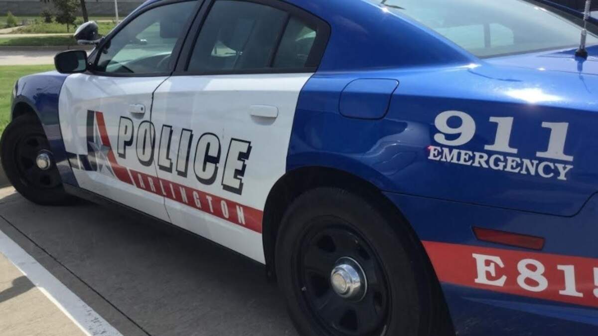A blue and white Arlington police car sits in a parking lot.